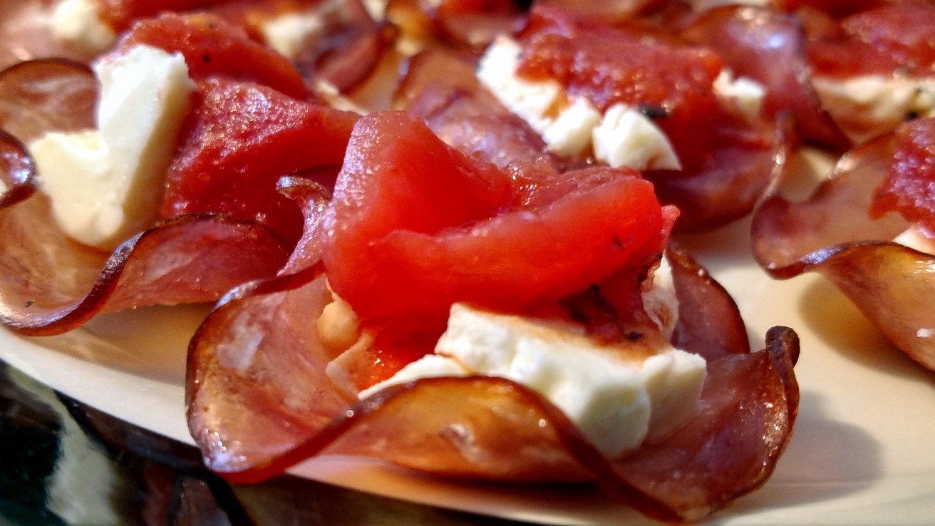 Canadian bacon feta cheese and tomato snacks served on plate