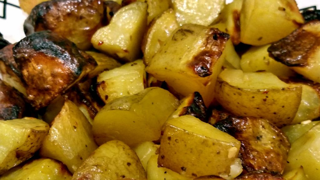 Garlic roasted potatoes in oven recipe on a plate close up view