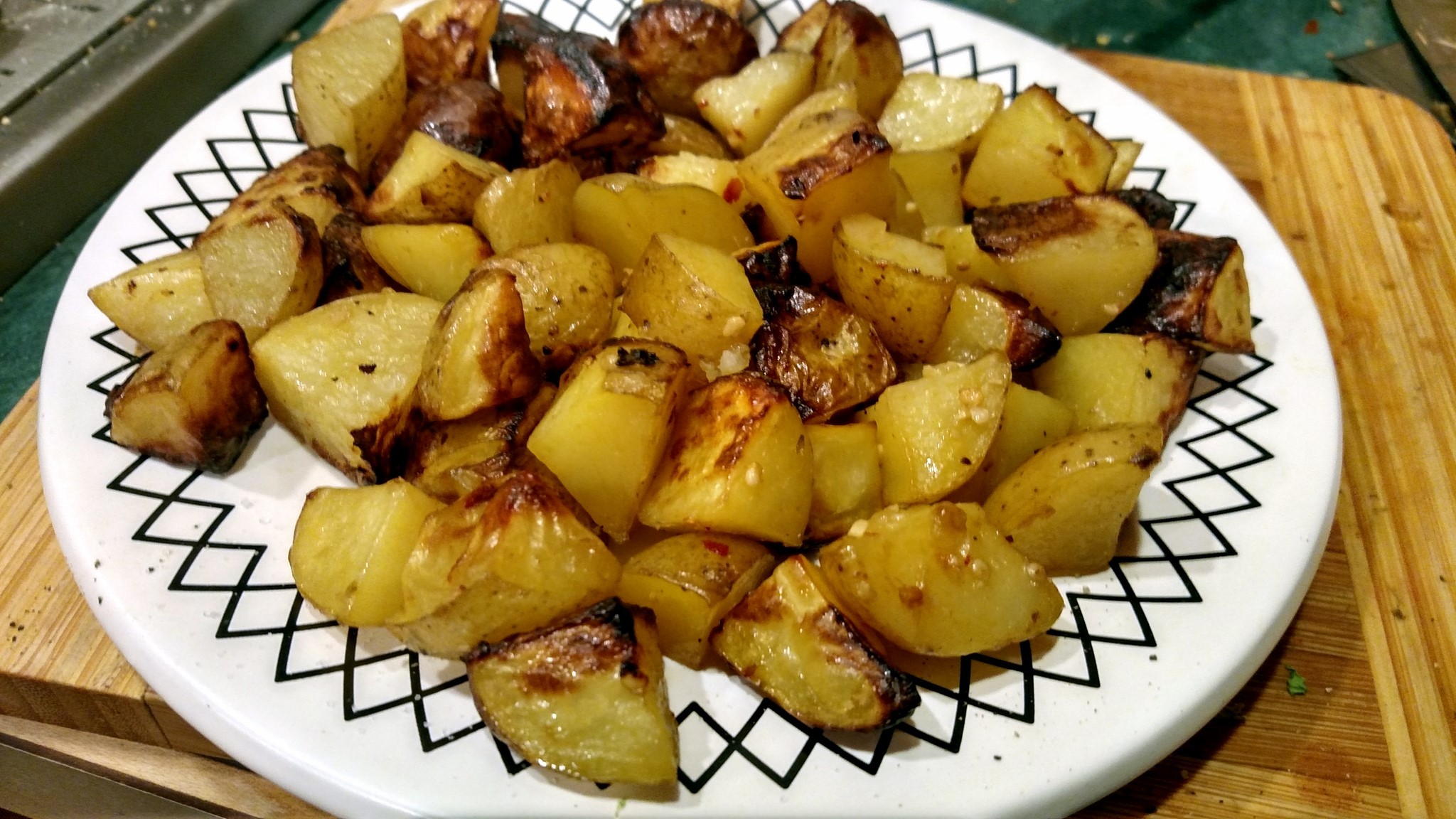 Garlic roasted potatoes in oven recipe on a plate perfect snack for bringe watching TV